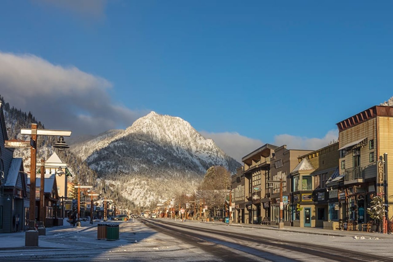 Frisco’s snowy main street with shops beneath a sunlit mountain.