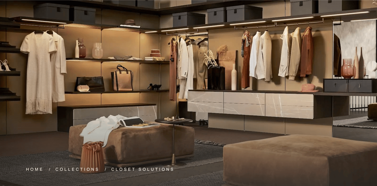 Walk-in closet with illuminated shelving, hanging clothes, marble-look drawers, and upholstered ottomans.