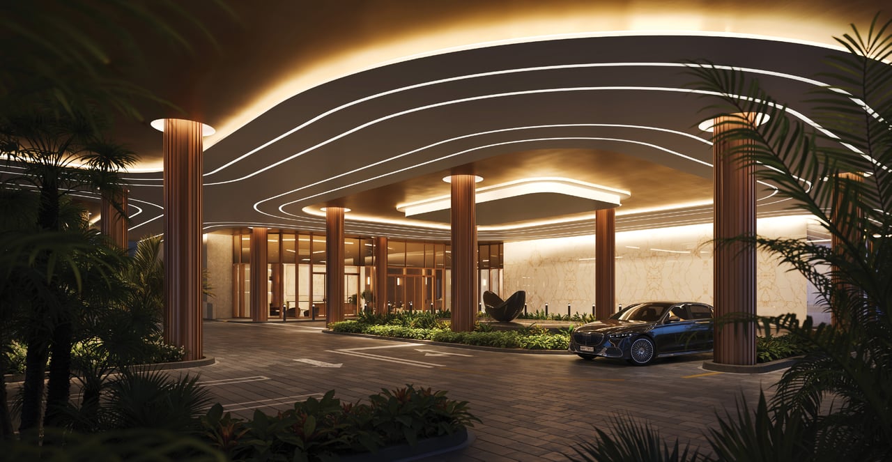 The Berkeley condominium entrance at night, with a curved illuminated canopy, columns, tropical plants, and a sedan.