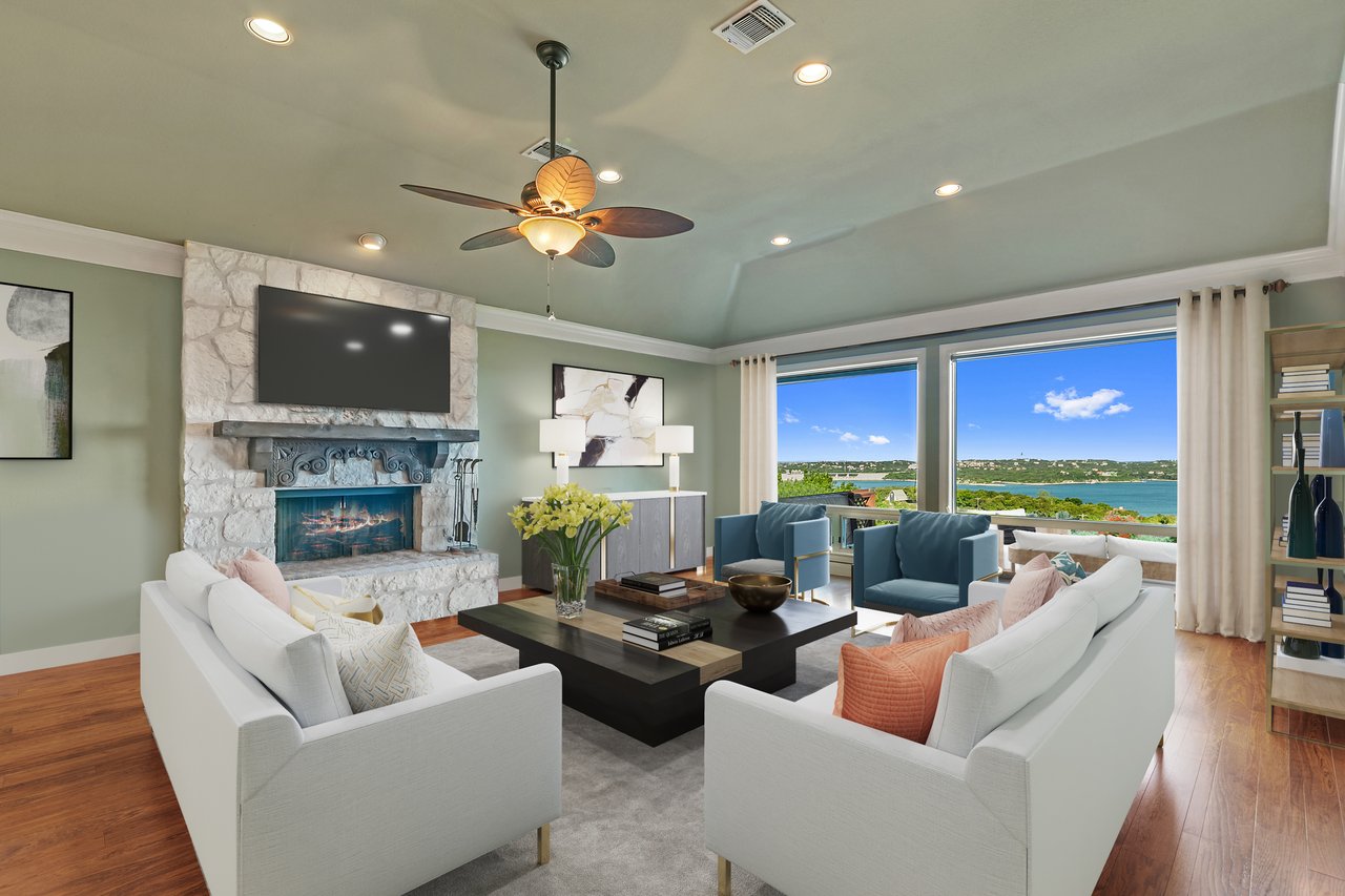 Living room with a stone fireplace, wood floors, and a wall of windows overlooking Lake Travis at 12709 Cedar St, Austin, TX (Hughes Park Lake).