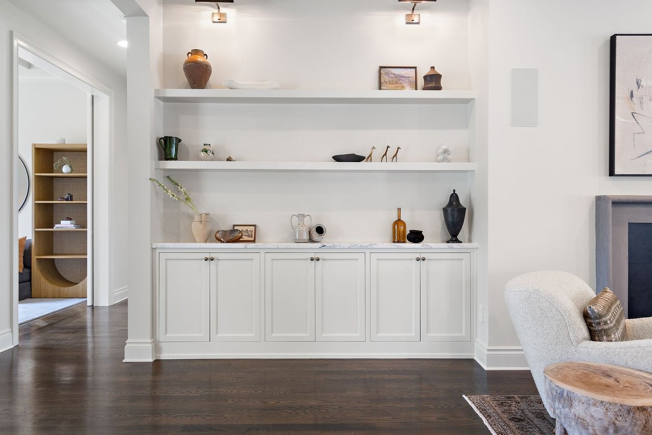 Built-in shelving display nook with a window bench and hardwood floors in the Tarrytown home at 2600 Westover Road, Austin.