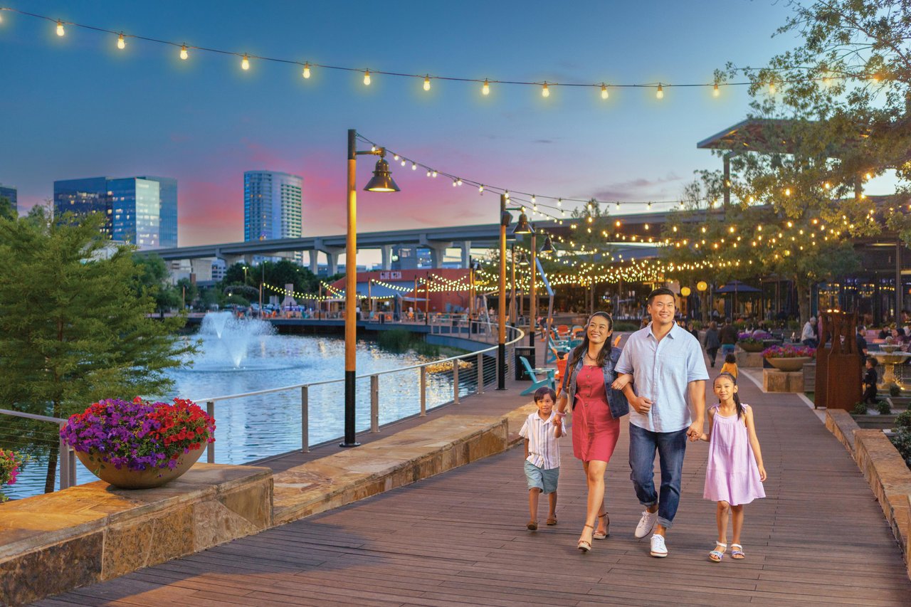 Family enjoying a sunset walk along the Tampa Riverwalk, showcasing the family-friendly lifestyle and attractions throughout Tampa Bay