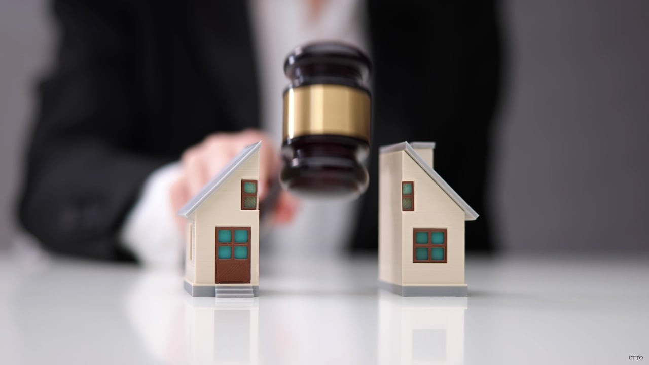 A judge’s gavel above two miniature houses, illustrating property decisions during divorce.