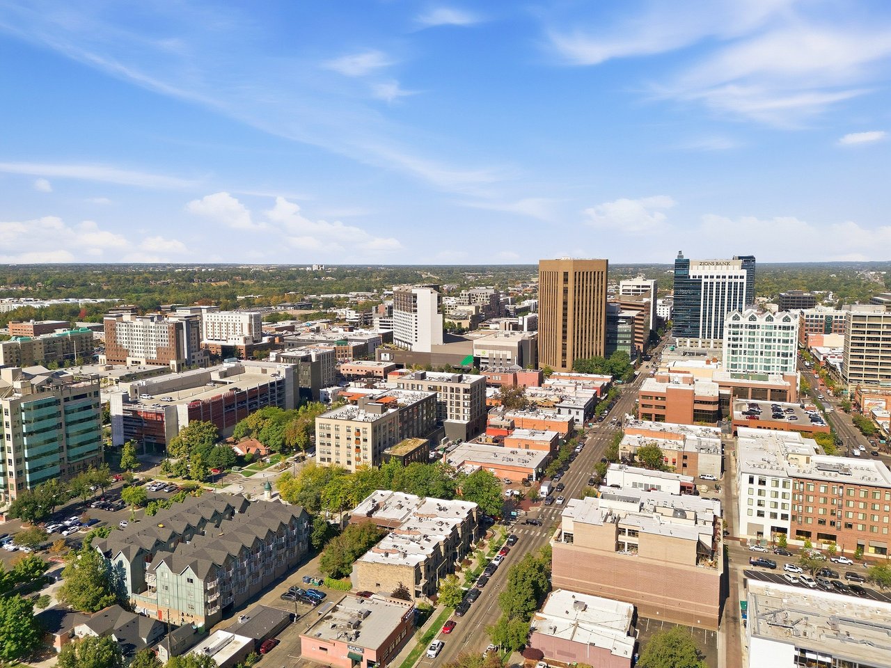 Aerial view of downtown Boise with the Zions Bank tower and tree-lined neighborhoods.