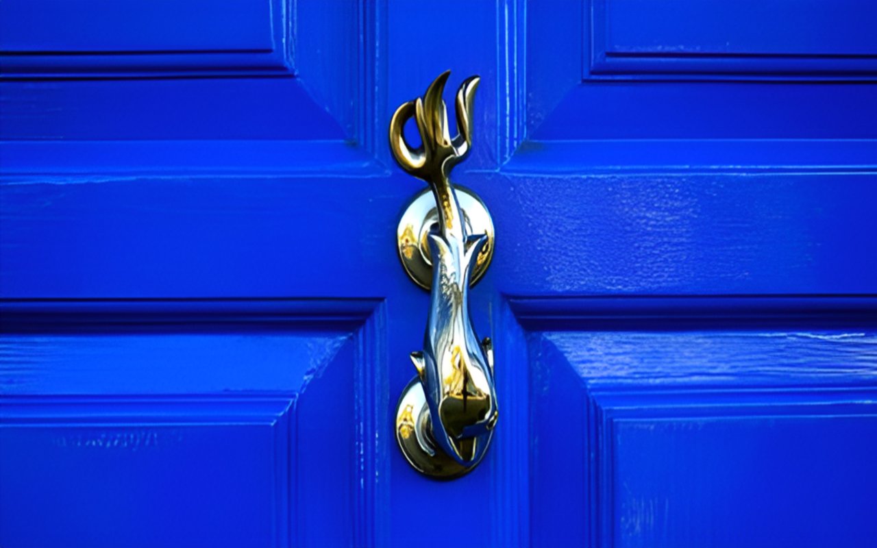 Vivid blue paneled door with an ornate brass knocker.
