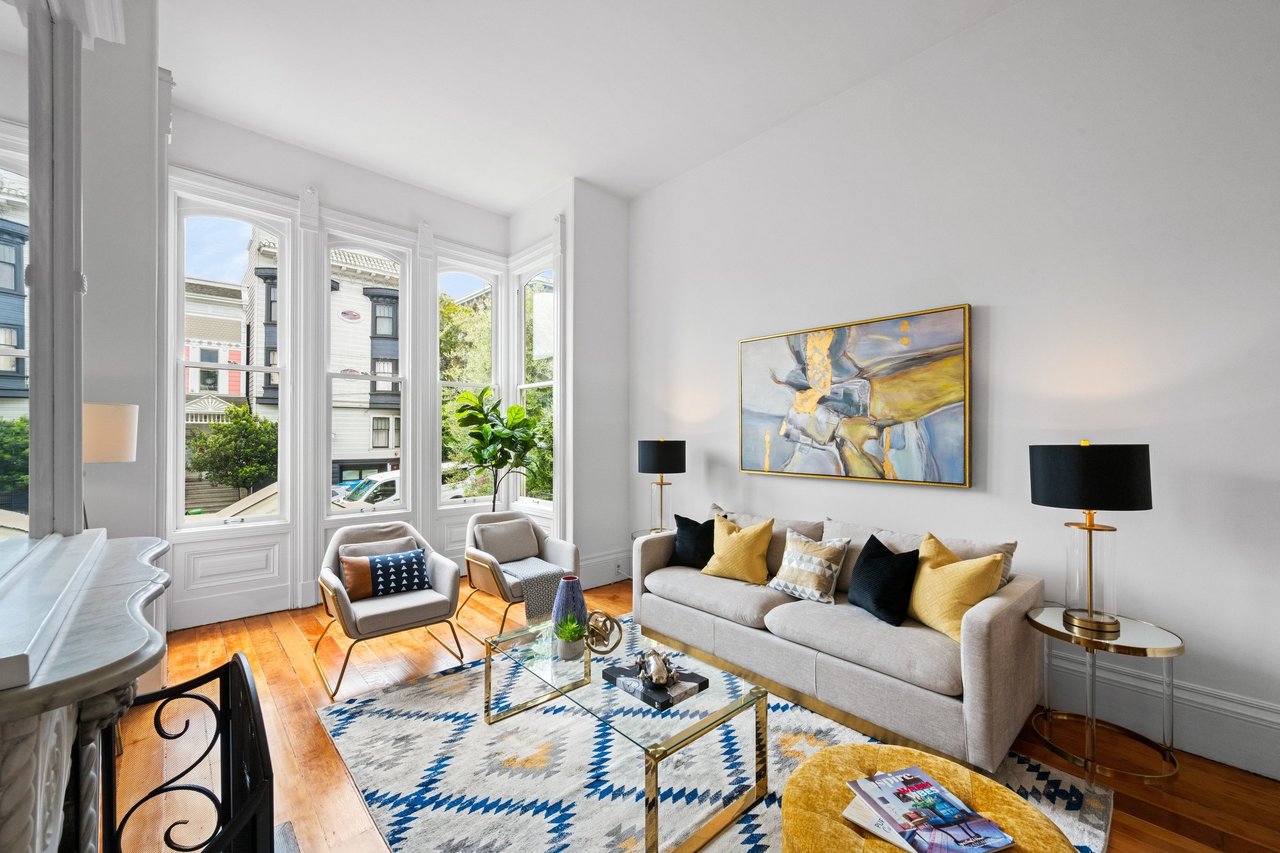 Beautifully staged San Francisco Victorian living room with bay windows, hardwood floors, and modern furniture, prepared for sale.