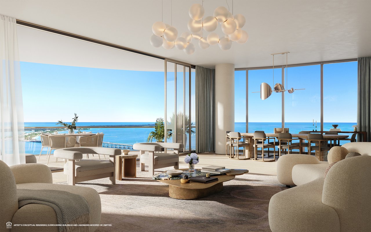 Furnished living and dining room with floor-to-ceiling windows overlooking the ocean.
