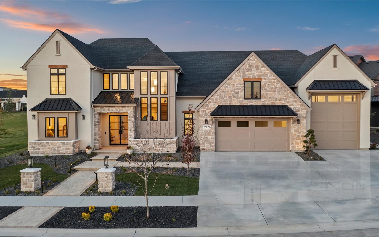 Front exterior of the home at dusk with lights on inside