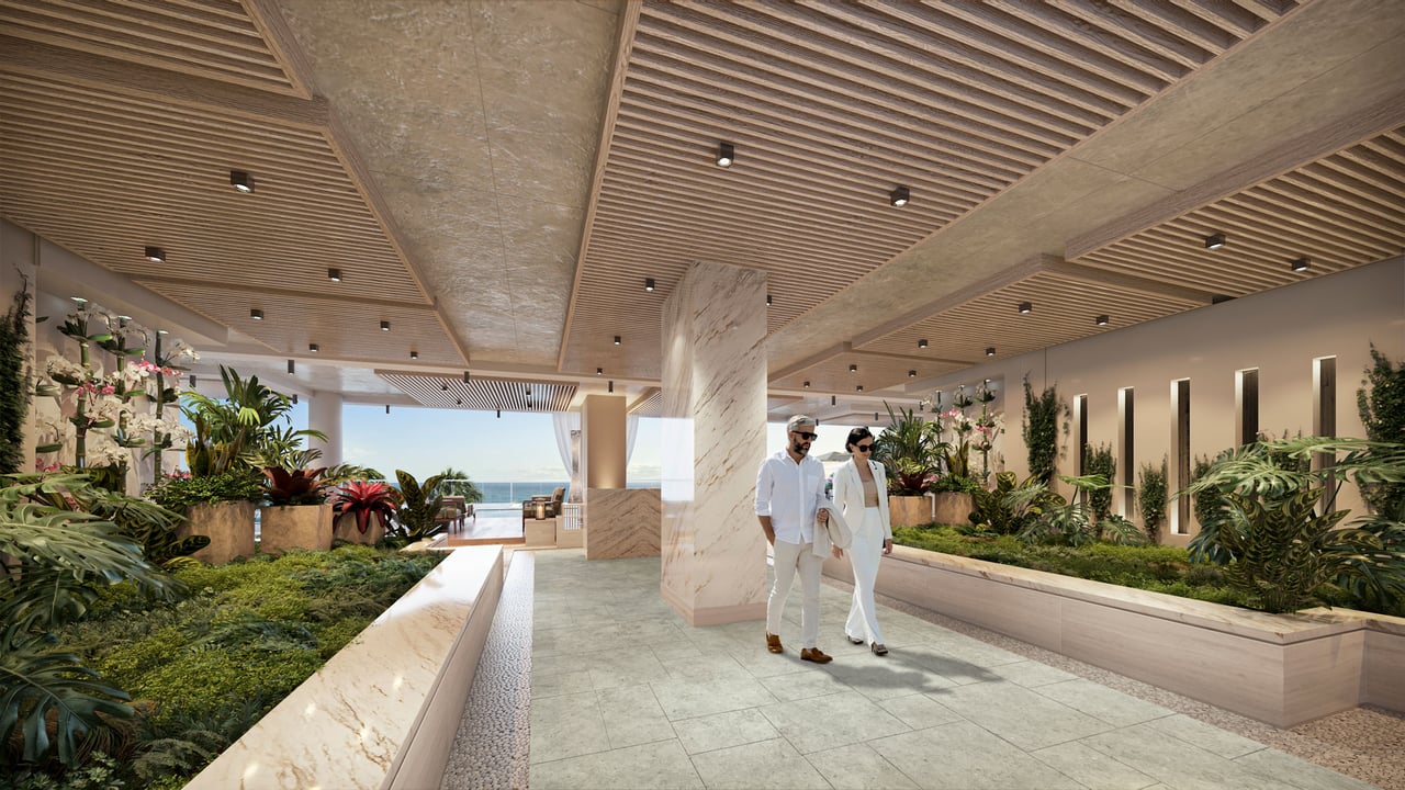 Landscaped residential lobby with a slatted wood ceiling, stone planters, and an ocean view.