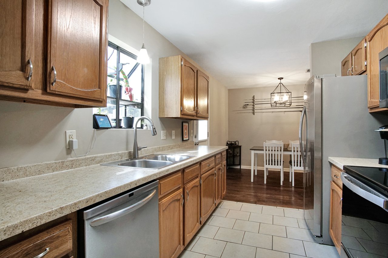 A modern kitchen featuring stainless steel appliances and elegant wood cabinets, showcasing a blend of style and functionality.