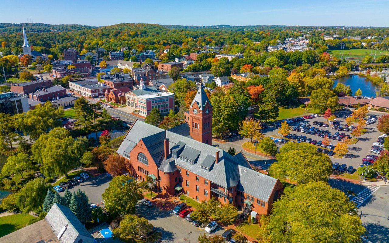Aerial view of Winchester town center, with a red-brick clock tower and autumn foliage.