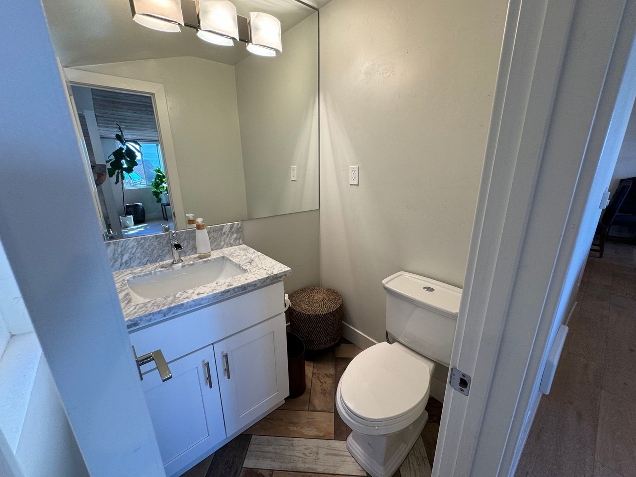 Bright bathroom with marble countertop vanity, modern lighting, and white cabinetry at 533 S Sierra Ave, Solana Beach, CA 92075 oceanview rental.