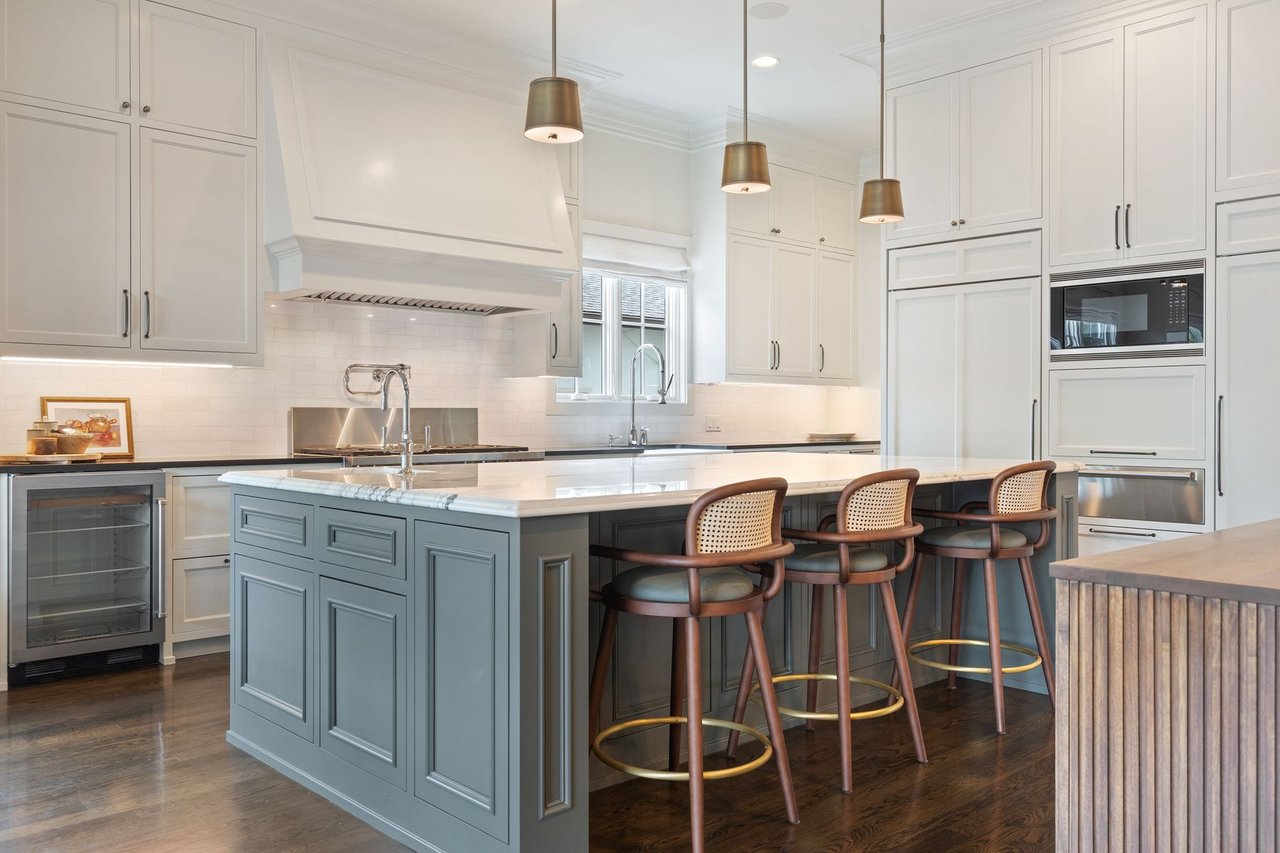 Kitchen with a large island, quartz countertop, and custom white cabinetry, built by Trey Smith Builders, at 2600 Westover Road in the Tarrytown neighborhood of Austin.