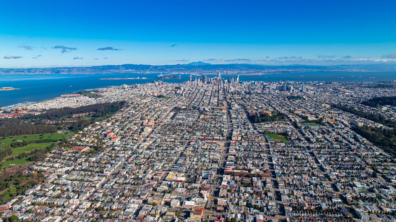 Aerial view of San Francisco's residential neighborhoods stretching toward the bay, the SF corridors served by Google's employee shuttle network to the Mountain View campus.