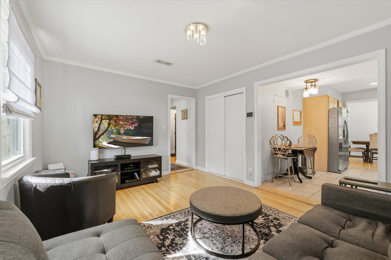 Living room with gray sofas and a round coffee table, opening onto the dining area and kitchen.