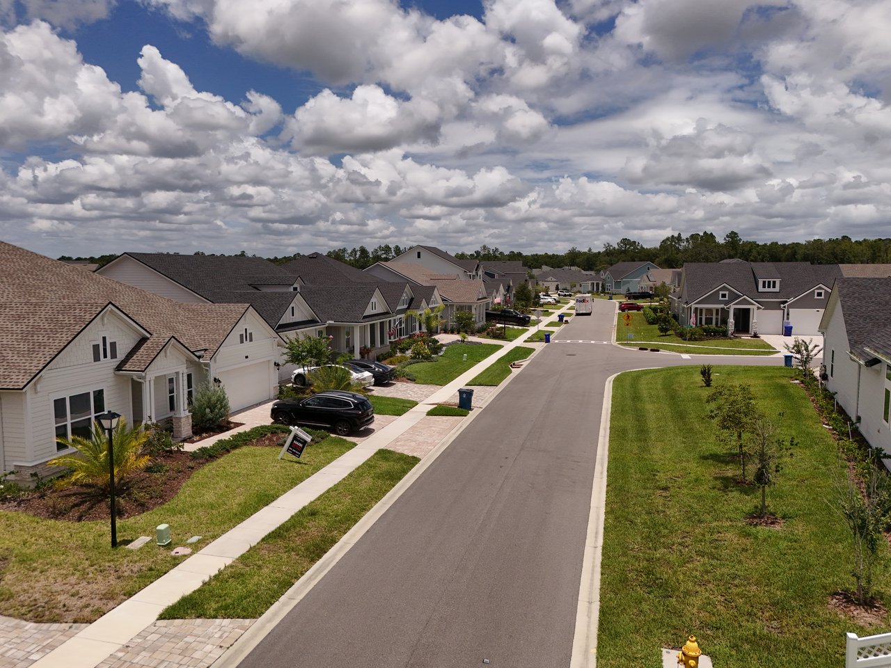 Oak Grove residential street lined with detached homes and lawns beneath a cloud-filled sky.