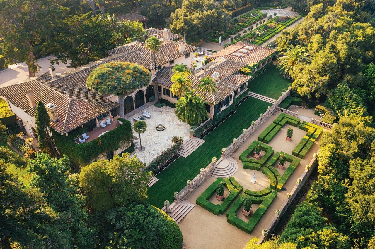 Aerial view of a Mediterranean estate with a tiled courtyard and formal gardens.