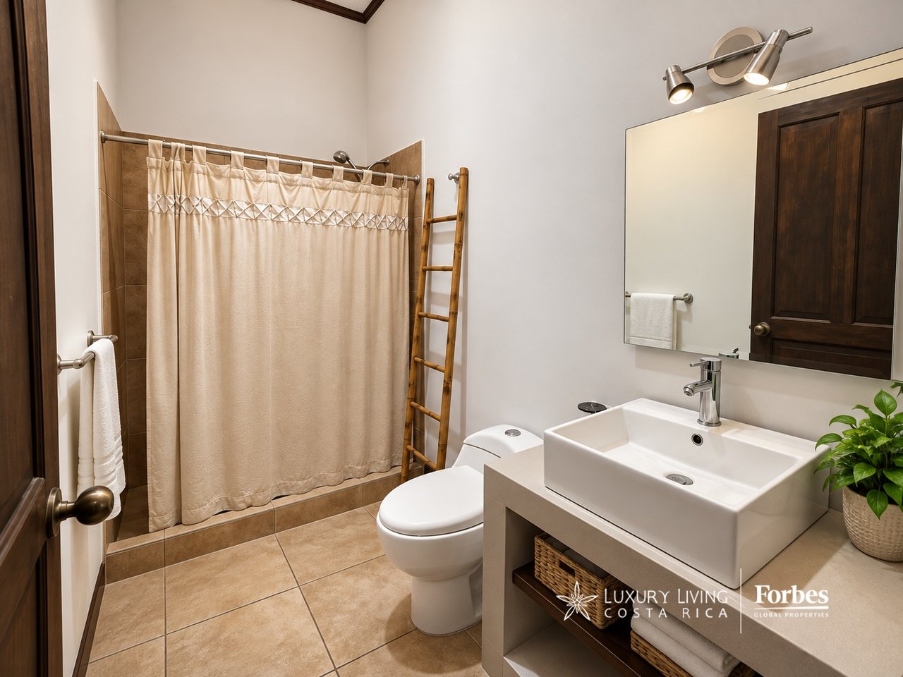 Bathroom with a beige shower curtain, wooden ladder, and square vessel sink beneath a large mirror.