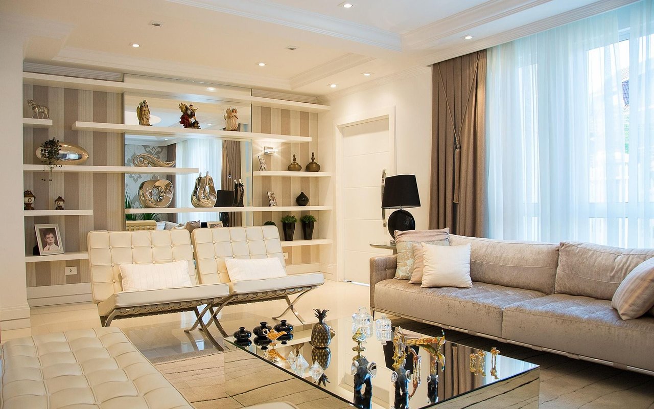 Furnished living room with built-in display shelves and a glass coffee table.