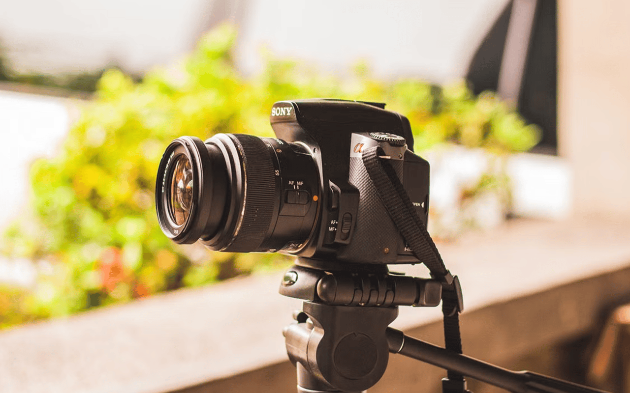 Sony camera with a large lens mounted on a tripod.