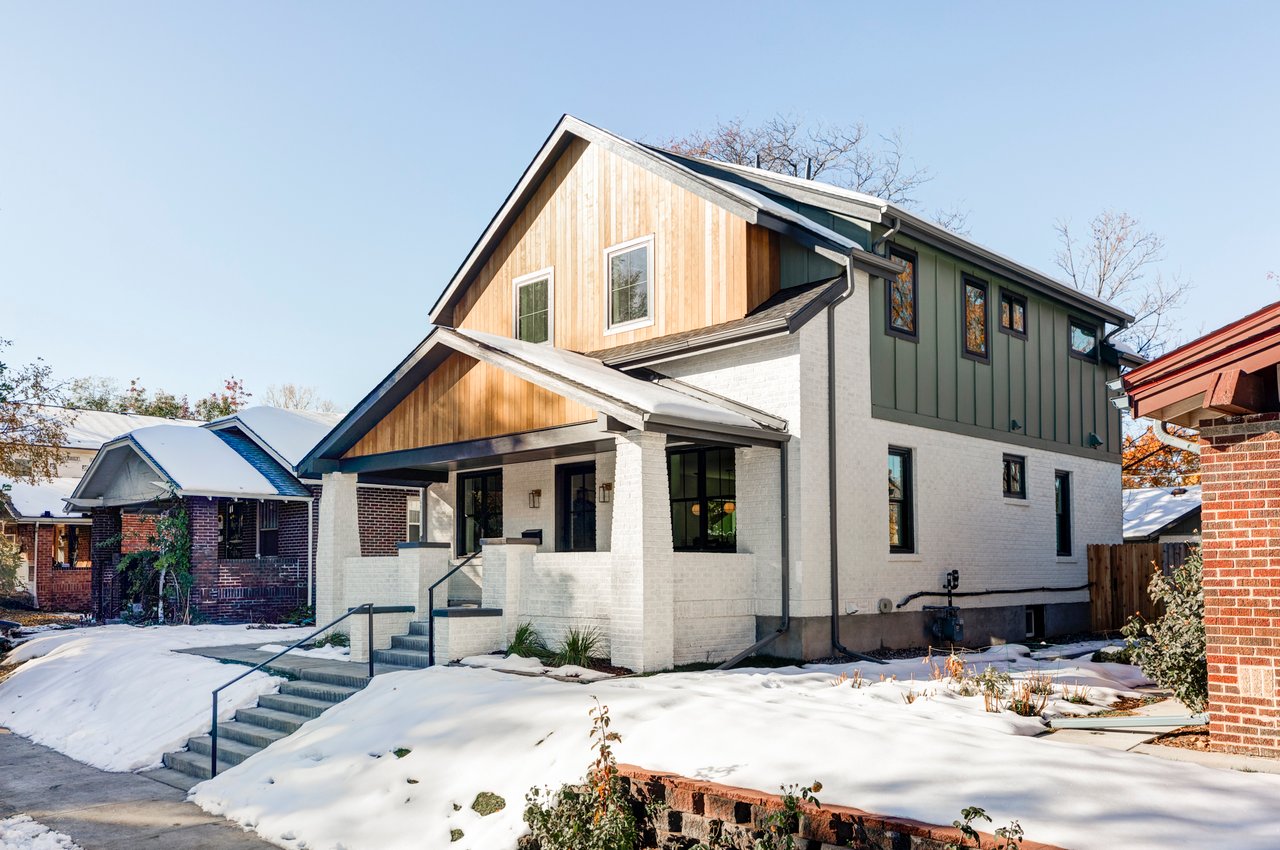 Side view of craftsman home showing sage green and wood siding details, white brick exterior, and concrete entry steps