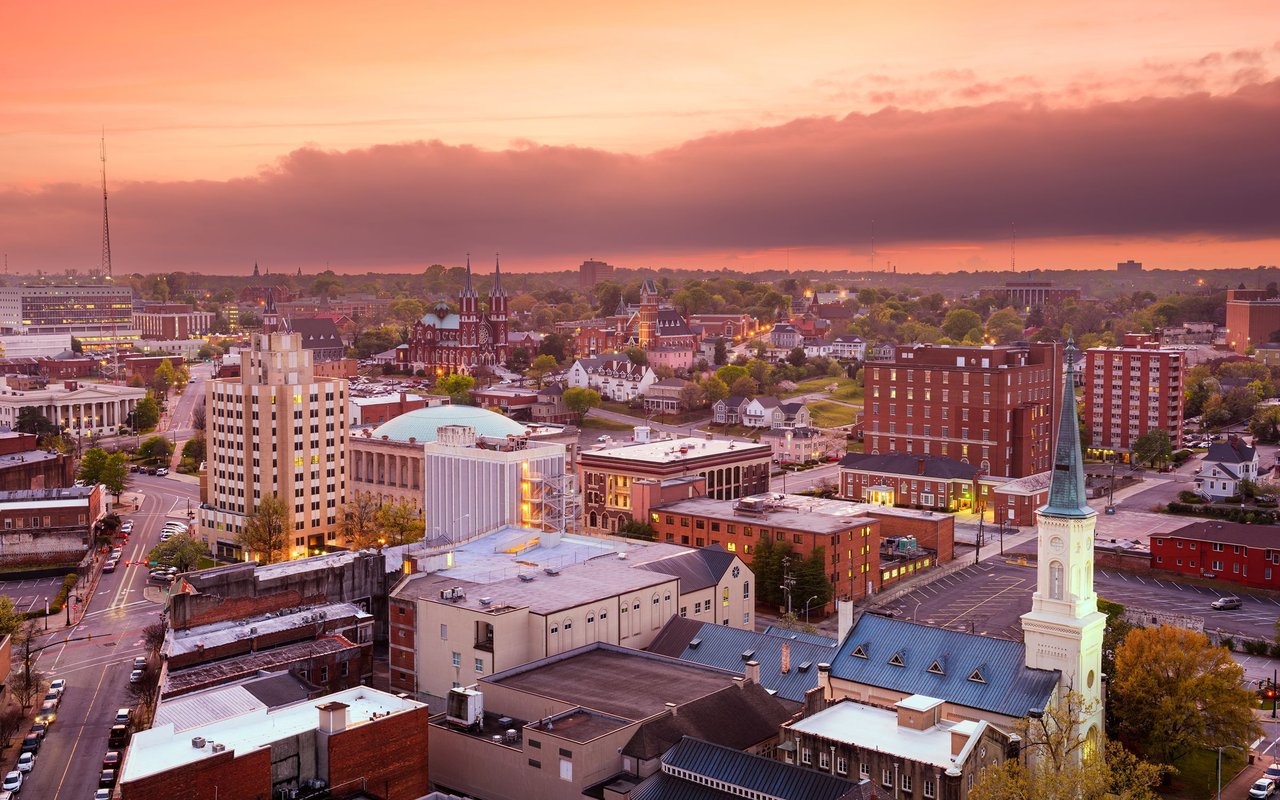Downtown Macon skyline at sunset, with historic buildings and church steeples.
