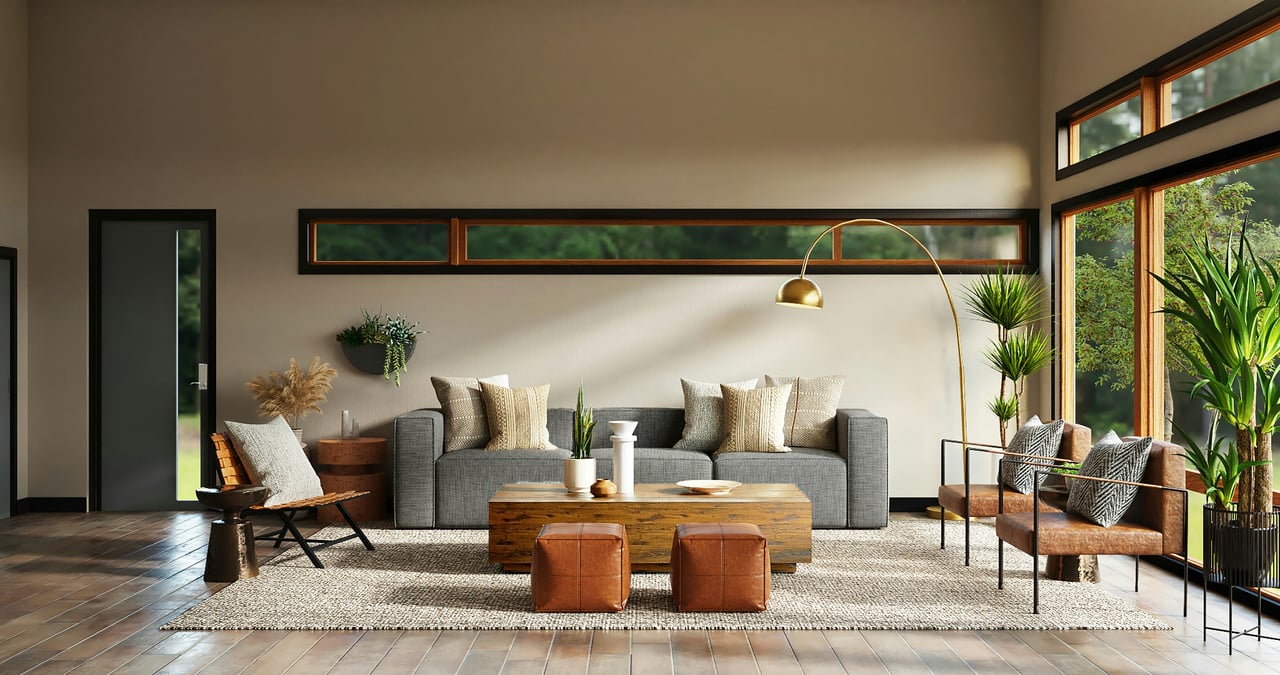 Sunlit modern living room featuring a gray sofa, leather accent chairs and ottomans, a rustic wood coffee table, large indoor plants, warm wood-framed windows, and a neutral textured rug.