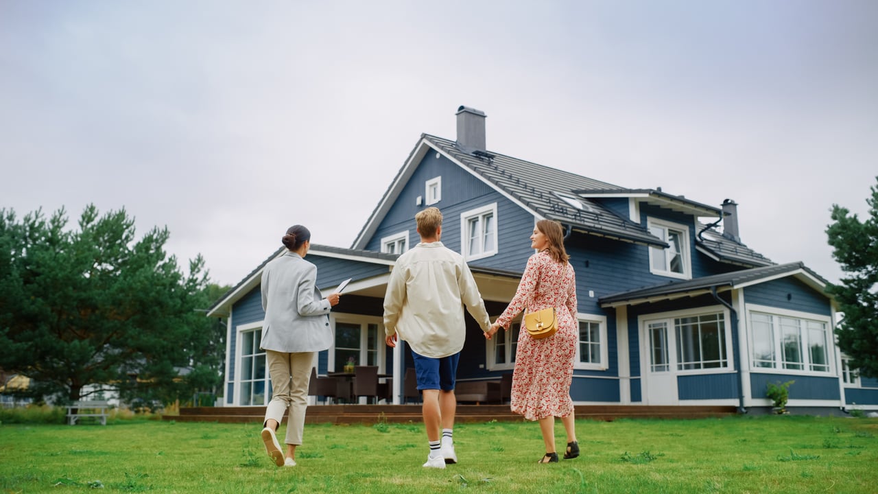 Couple touring a home with real estate agent — ideal setting for selling a residential property