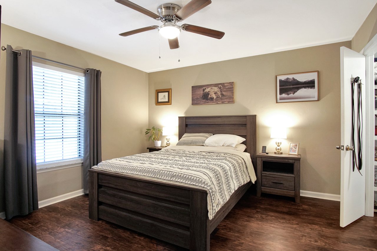 A cozy bedroom featuring a bed, a dresser, and a ceiling fan for comfort and style.