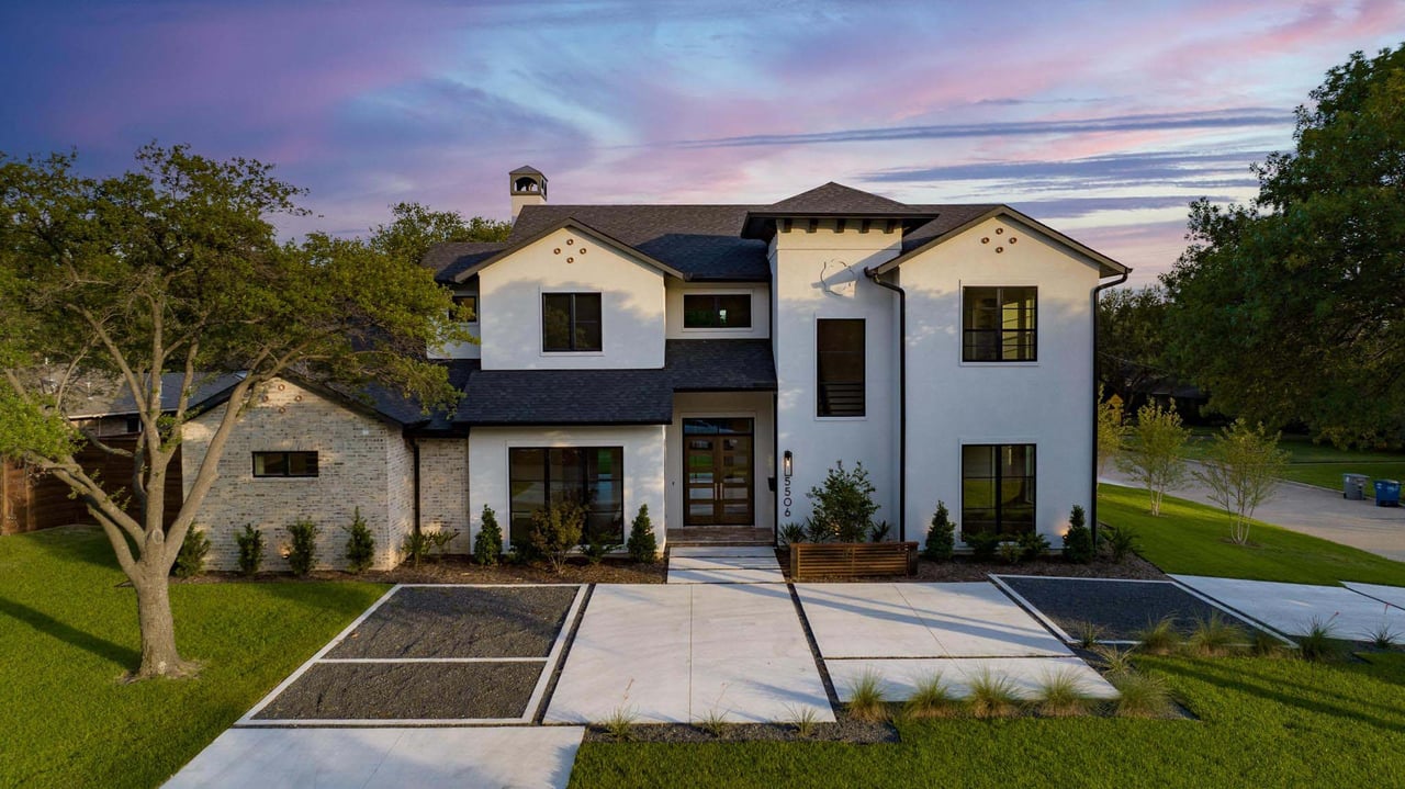  A stunning Mediterranean-style custom villa in Whitney Oaks, Rocklin, showcasing elegant stone masonry and manicured curb appeal at sunset.
