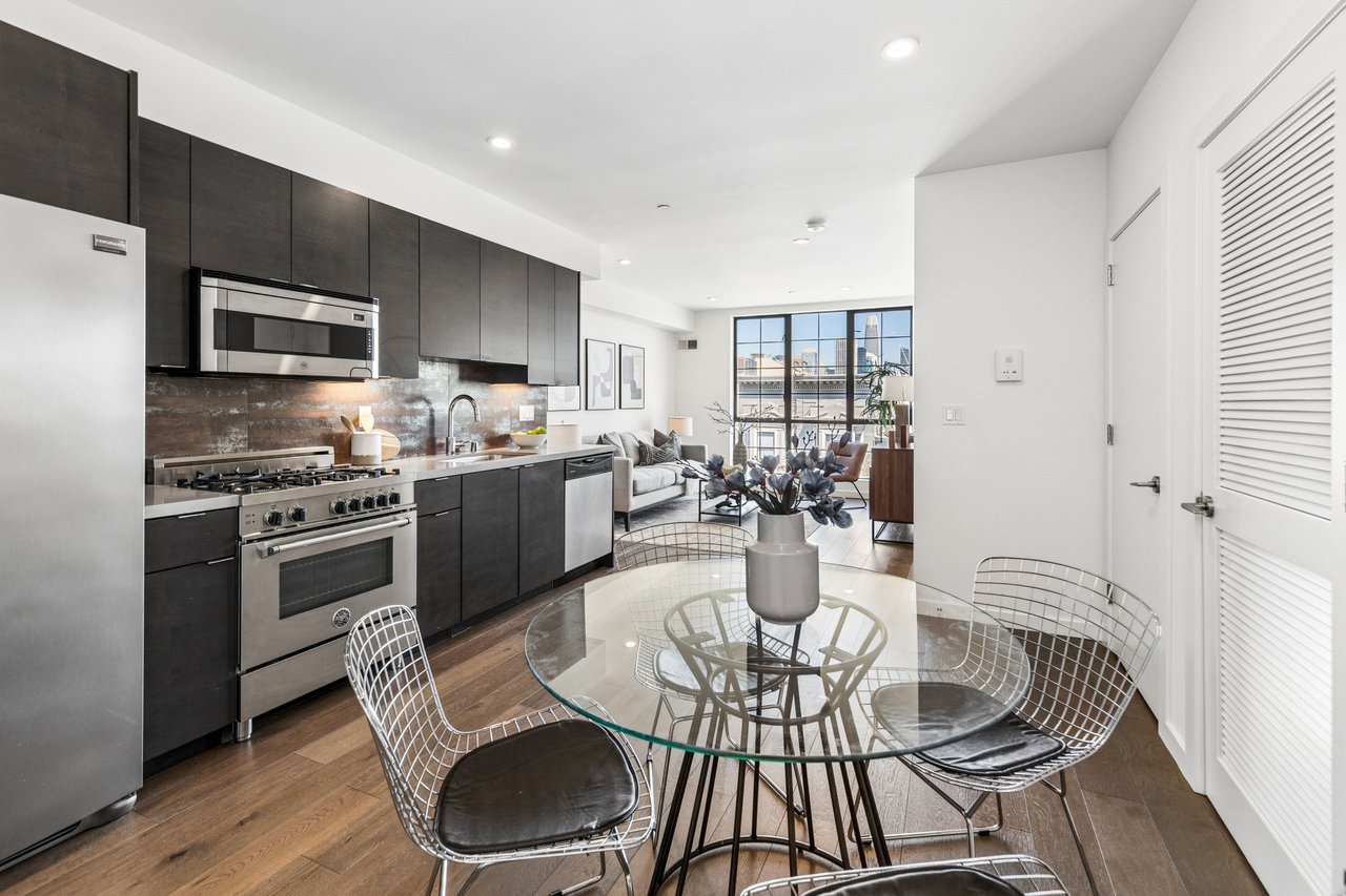 Stylish dining area adjacent to a sleek chef’s kitchen, offering a perfect blend of functionality and modern design for hosting and daily living.