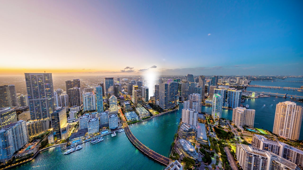 Aerial view of Brickell high-rises and Biscayne Bay at sunset.