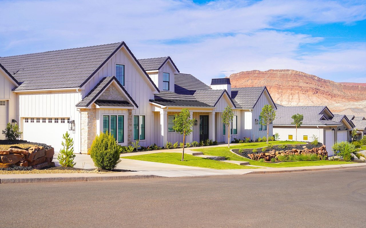 Modern homes in Prospector with landscaped lawns and red-rock mountain views.