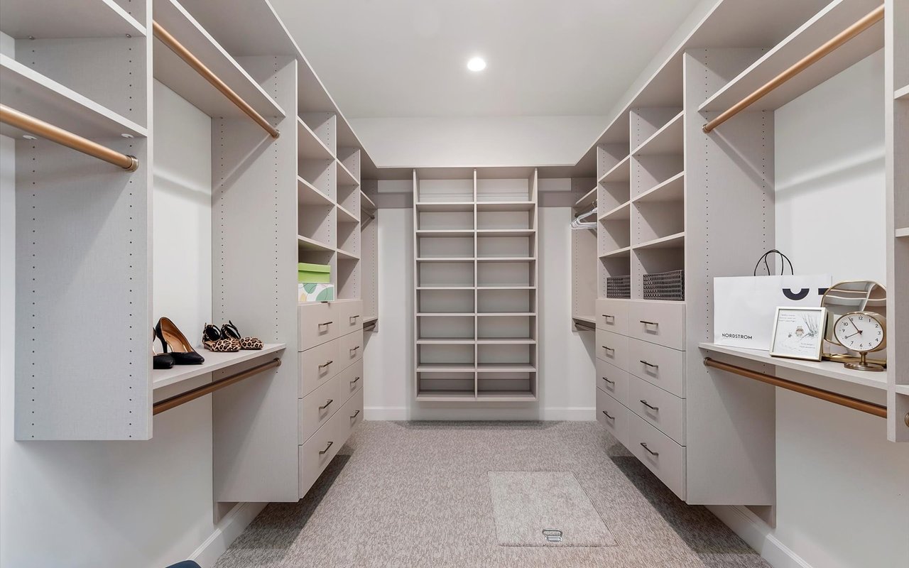 Primary bedroom walk-in closet with drawers and cubbies