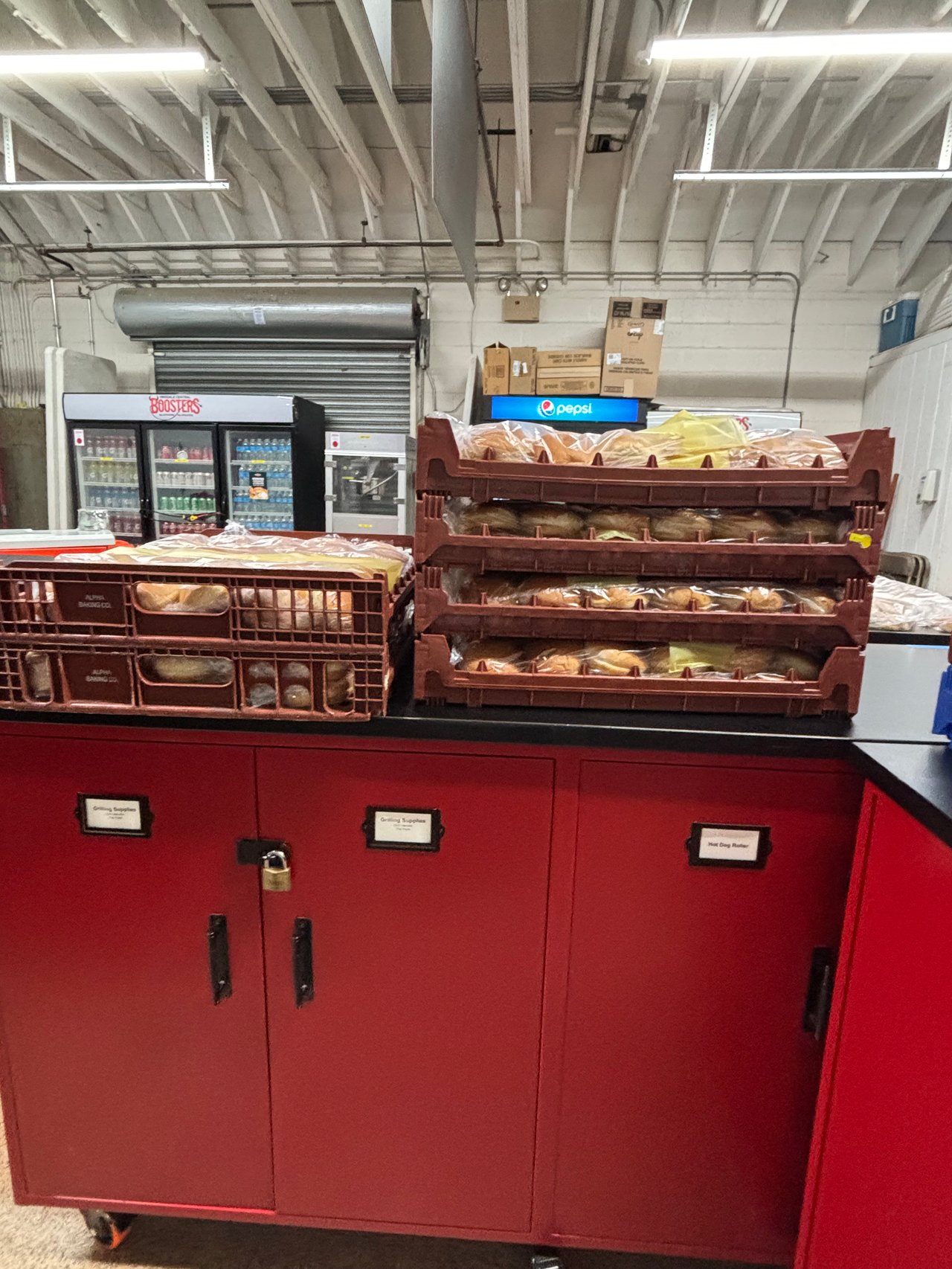 School concession stand with red cabinets, bread racks, and drink refrigerators.