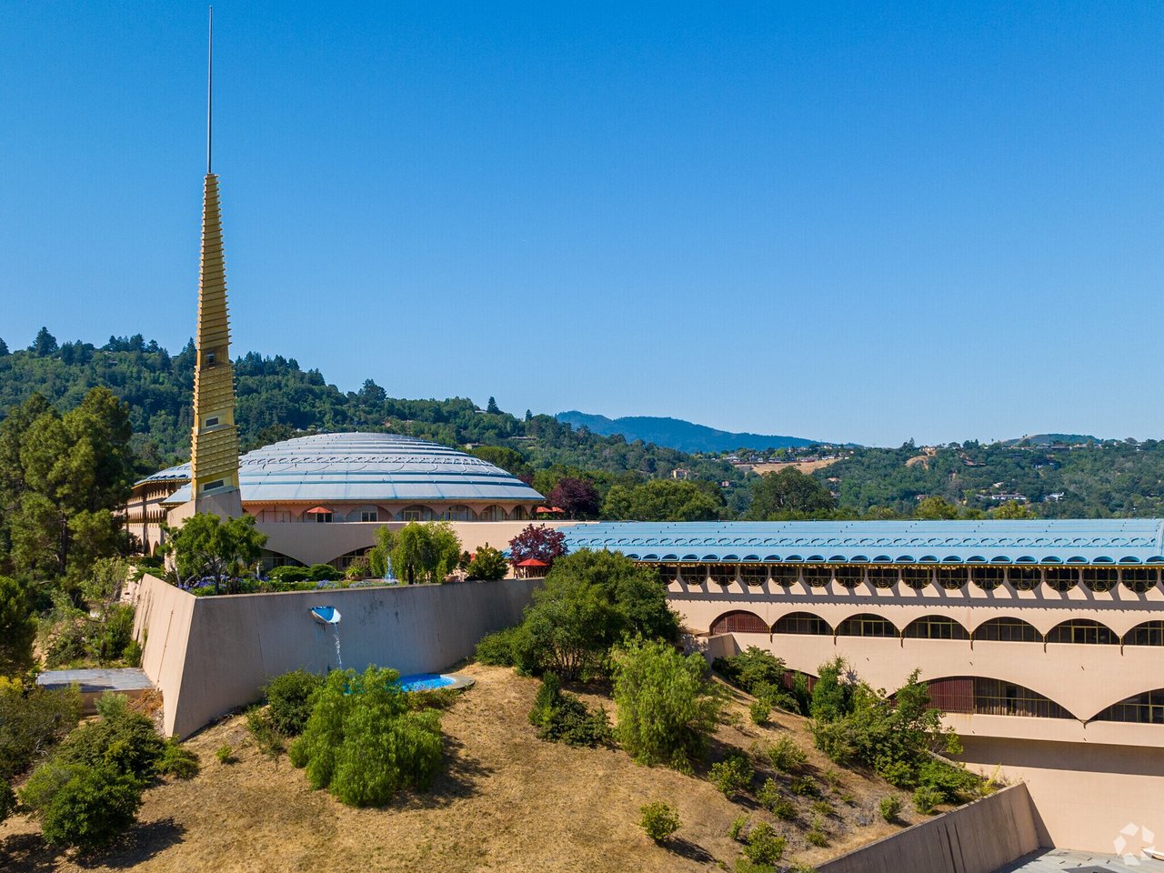Marin County Civic Center’s gold spire and long buildings against wooded hills.