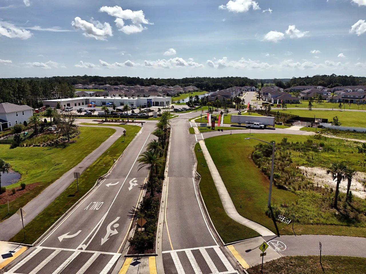 Aerial view of a residential development with rows of homes and a landscaped entrance intersection.