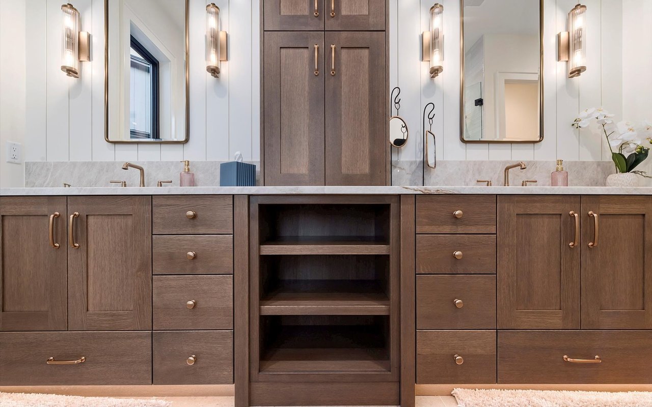 Primary ensuite close-up of the wood custom cabinets with brass hardware