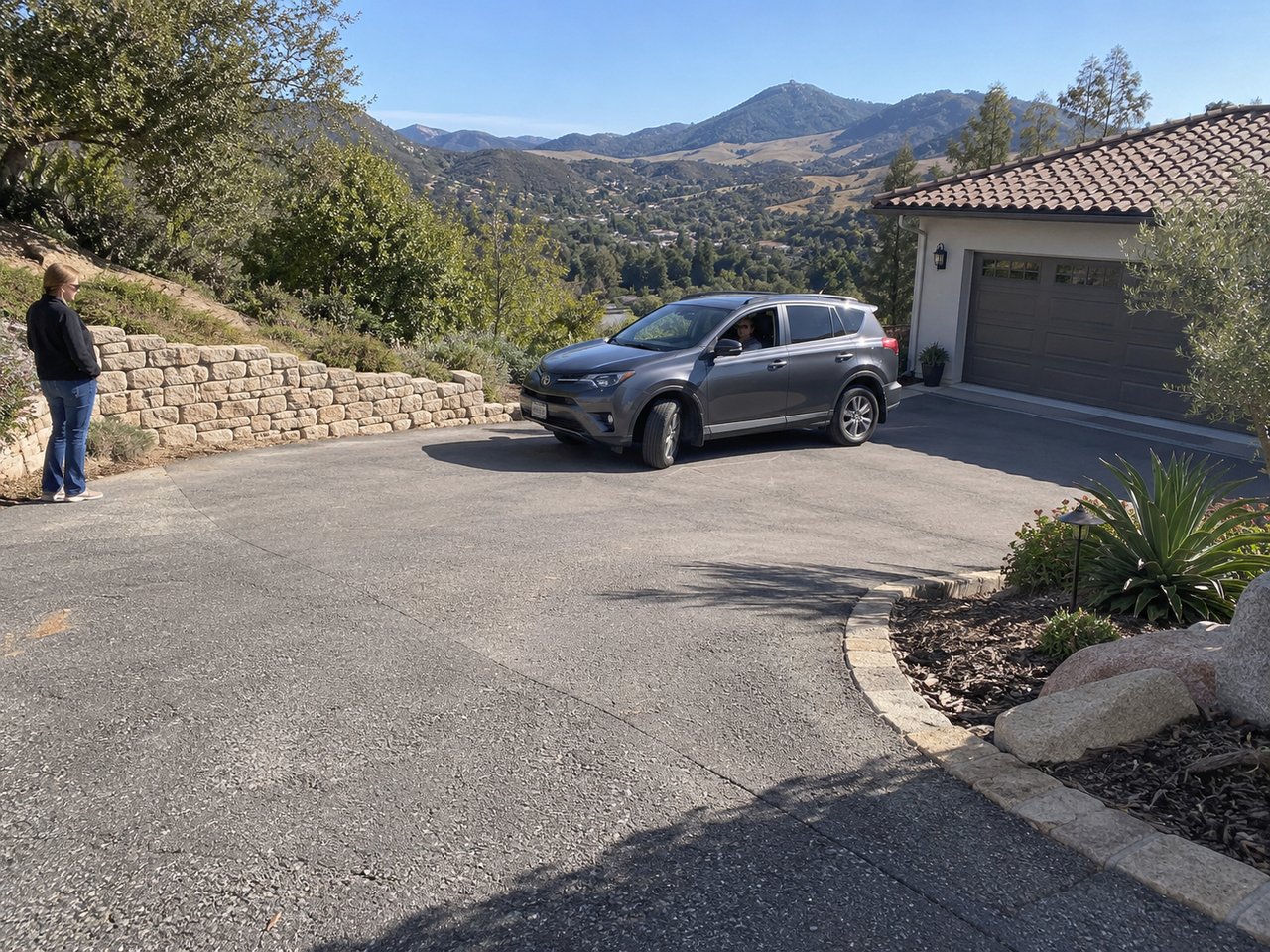 A buyer slowly maneuvers through a hillside turning court while the driveway grade, garage approach, and available vehicle clearance remain fully visible.