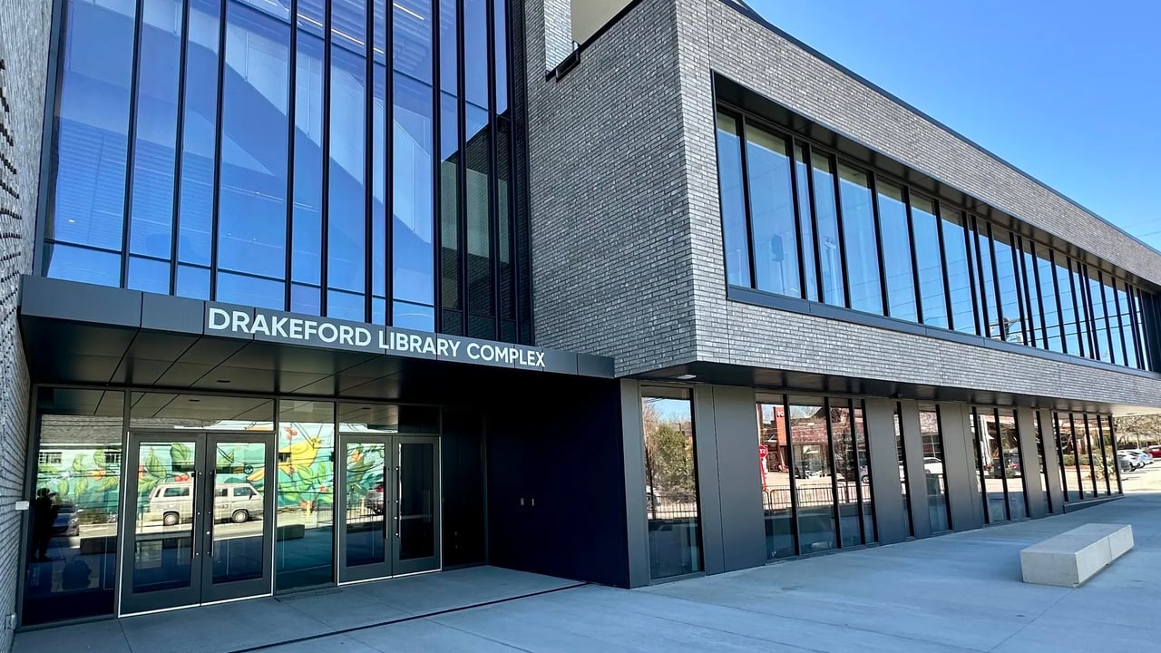 Drakeford Library Complex in Carrboro, with a gray brick facade and large blue-tinted windows.