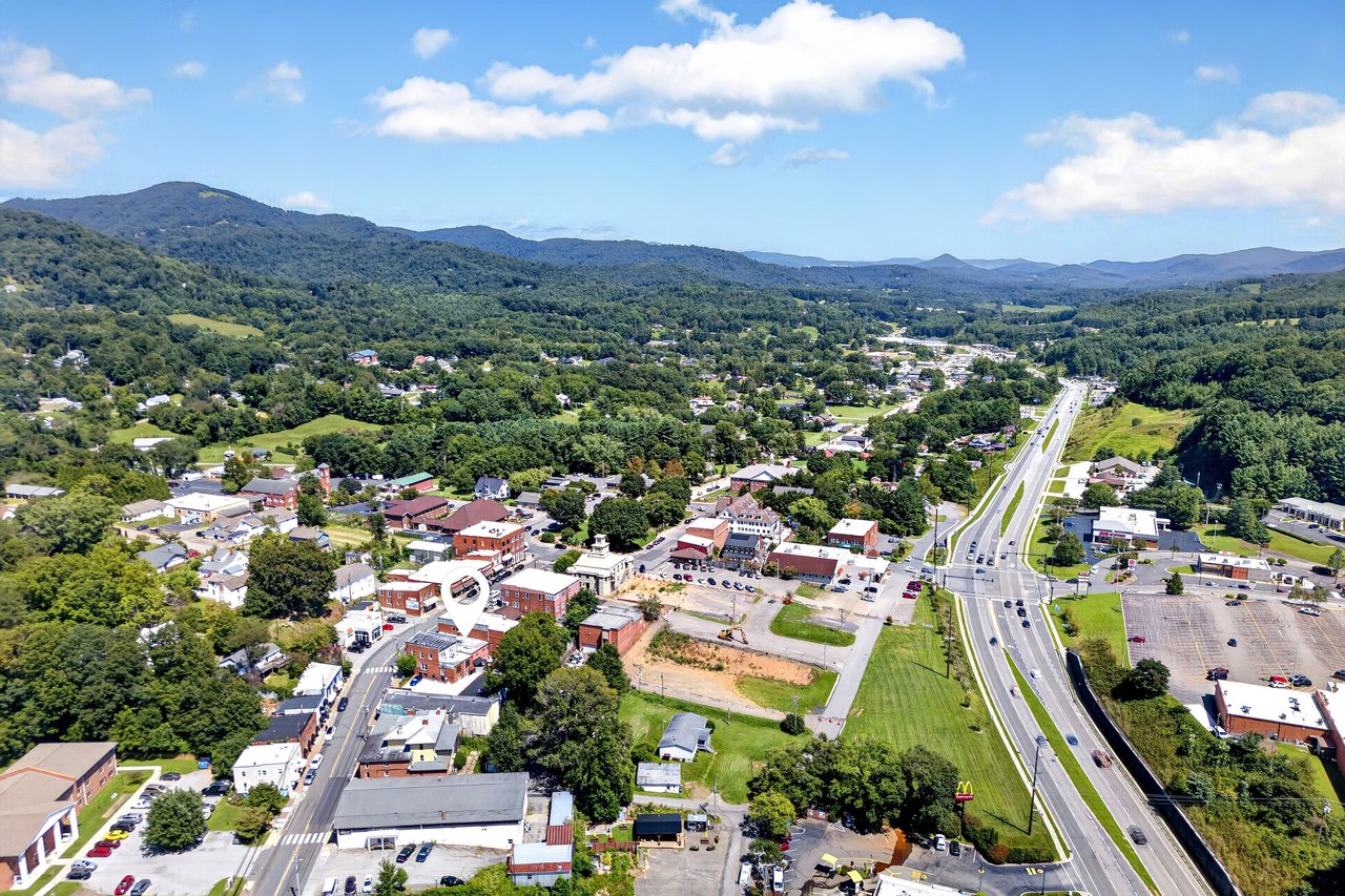 Aerial view of downtown Burnsville, with the property marked and wooded mountains beyond.