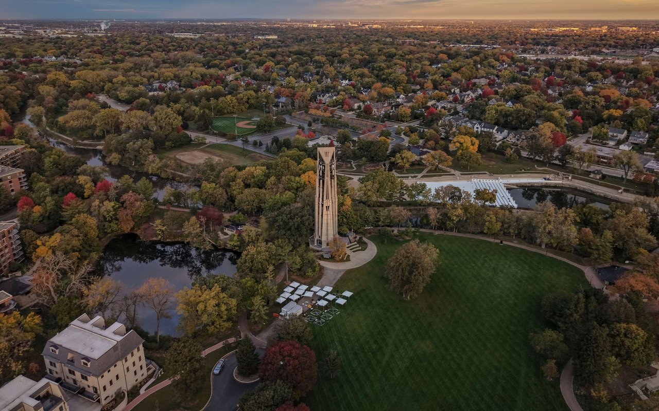 Aerial view of Naperville’s Moser Tower and park, surrounded by autumn trees and downtown neighborhoods.