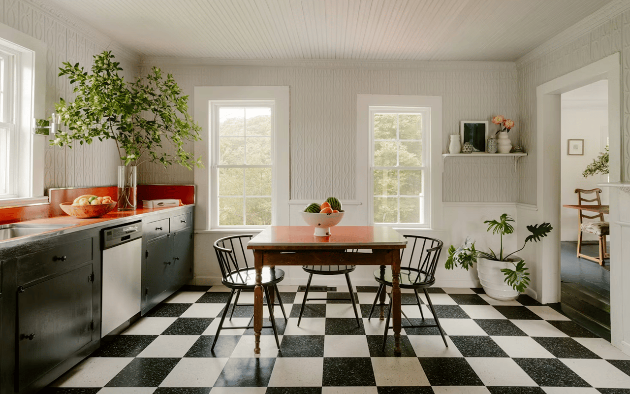 Kitchen with dark green cabinets, a wooden dining table, and a checkerboard floor.