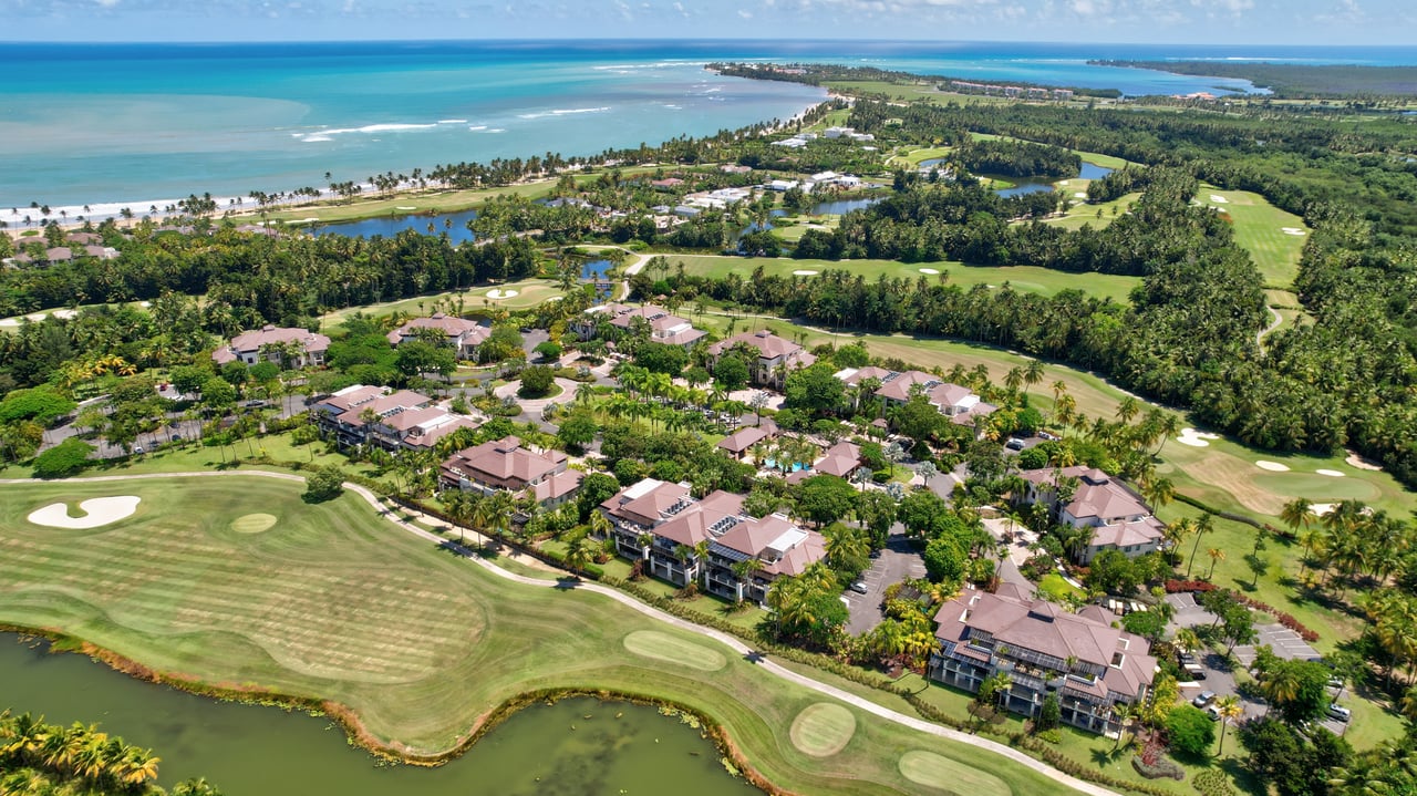 Aerial view of Bahia Beach Resort featuring luxury residences, a golf course, lush greenery, and a coastline with ocean views.