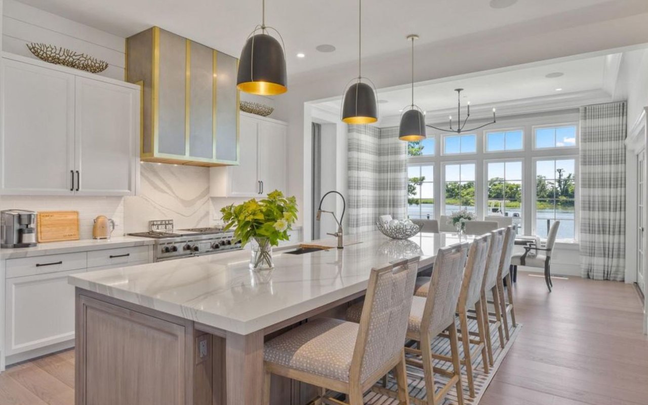 Luxury kitchen with a marble island and dining area overlooking the water
