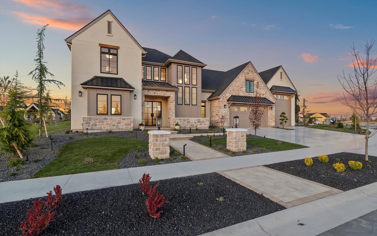 Front exterior of the home showing the curbs, sidewalk, and stone pavers leading up to the main entrance