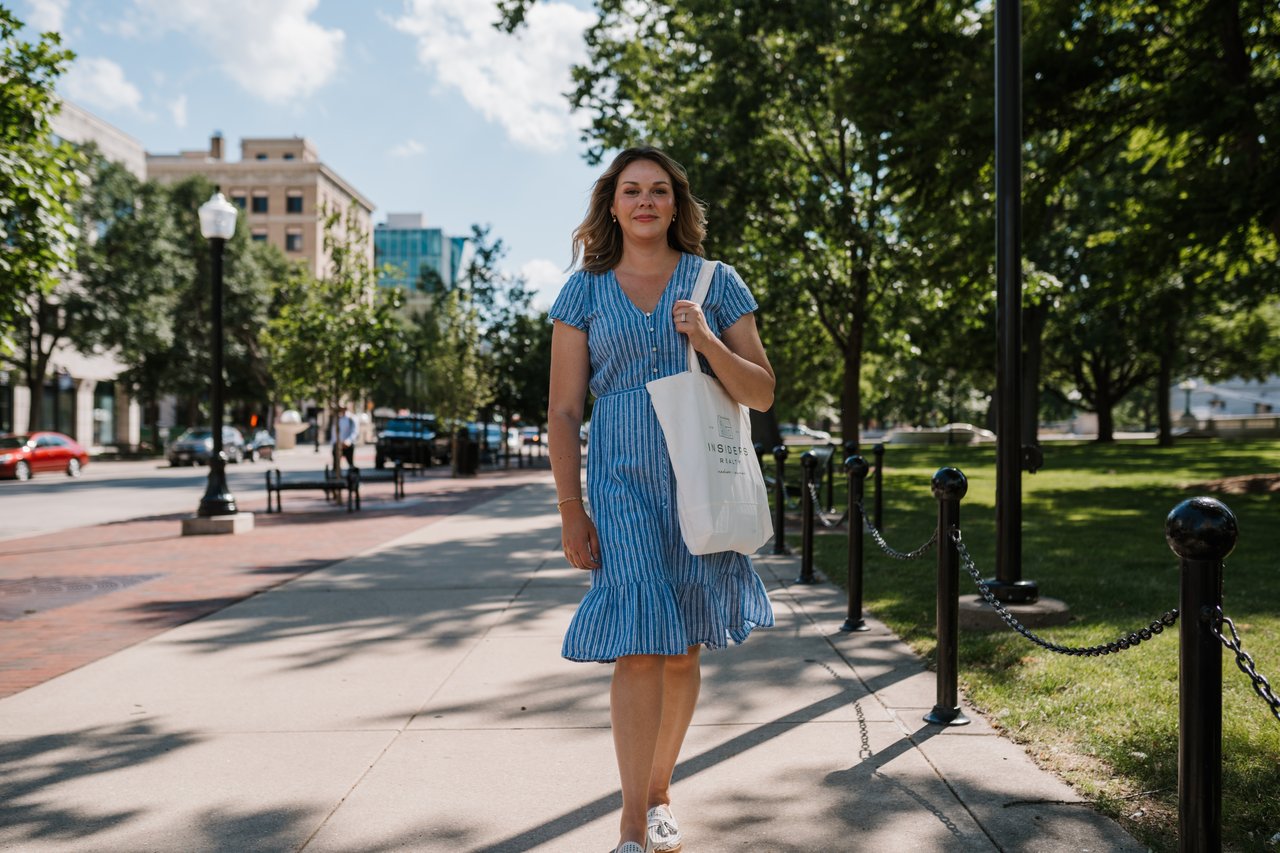 A view of Cait Berry walking in downtown Madison, WI, with Wisconsin State Capitol Square in the foreground, showcasing the city's vibrant lifestyle.