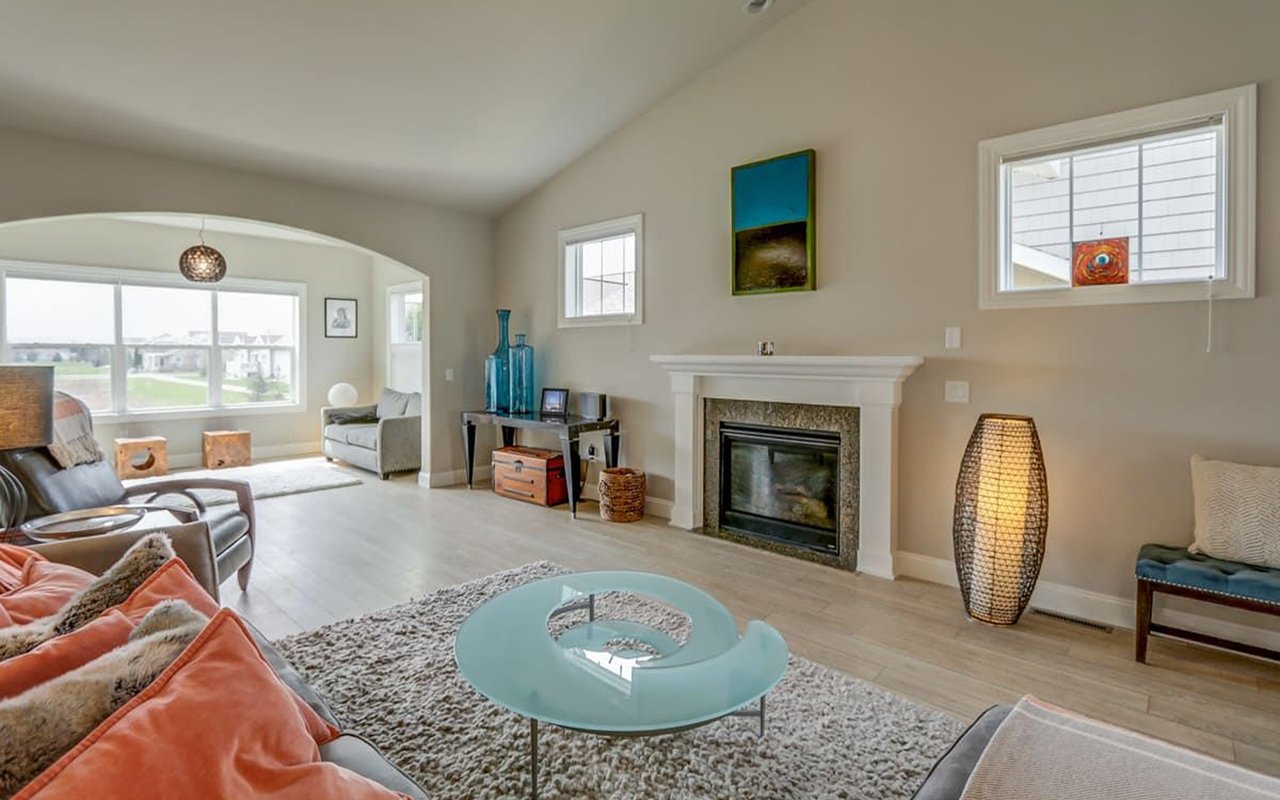 Living room with a fireplace, arched sitting area, and glass coffee table.