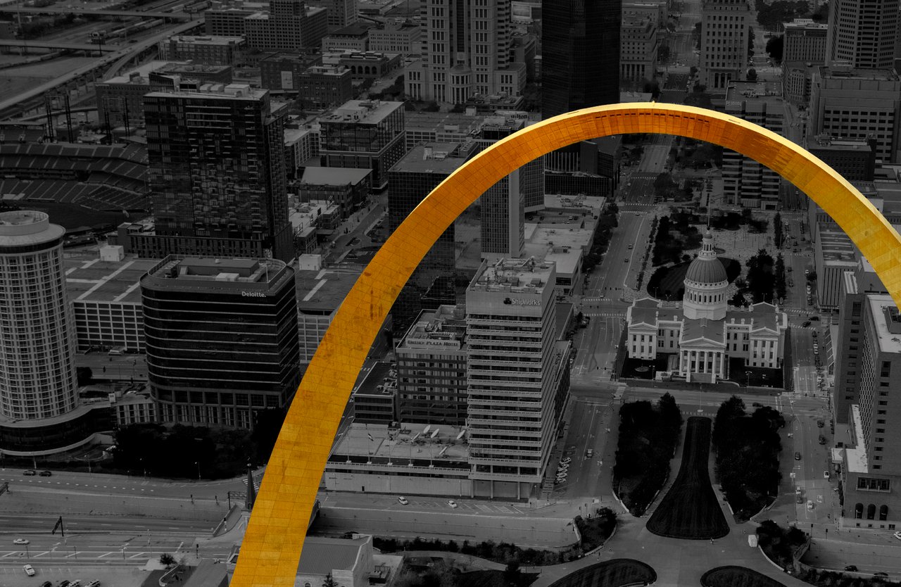 Downtown St. Louis and the domed Old Courthouse beneath the golden Gateway Arch.