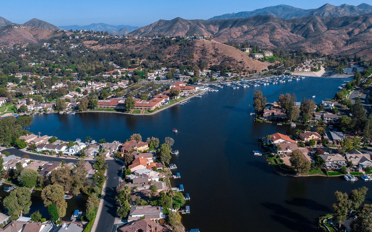 Westlake Village homes line a lake beneath dry, rugged mountains.